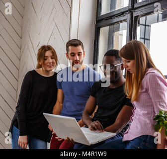 Group of international students using laptop. Studio shot Stock Photo