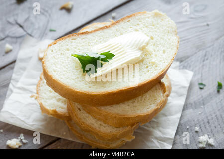 Butter and bread for breakfast, with parsley over rustic wooden background, top view Stock Photo