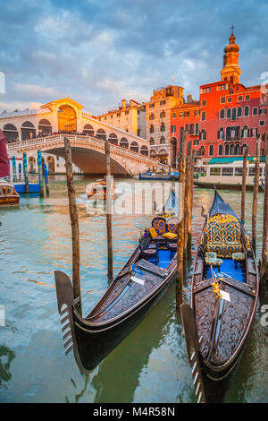 Classic panoramic view with traditional Gondolas on famous Canal Grande with famous Rialto Bridge in the background in beautiful golden evening light  Stock Photo