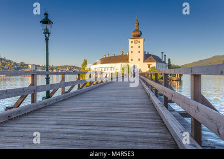 Beautiful view of famous Schloss Ort with wooden bridge at Lake Traunsee in beautiful golden evening light at sunset, Gmunden, Salzkammergut region, A Stock Photo