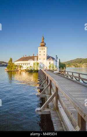 Beautiful view of famous Schloss Ort with wooden bridge at Lake Traunsee in beautiful golden evening light at sunset, Gmunden, Salzkammergut region, A Stock Photo