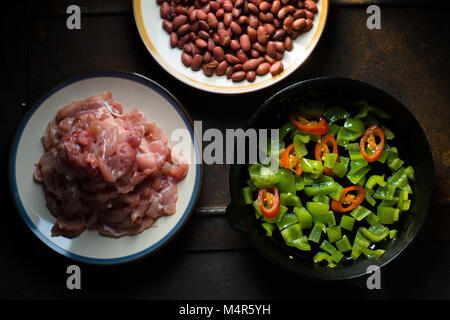 Pieces of chicken, beans. Pepper and chili in a frying pan top view horizontal Stock Photo