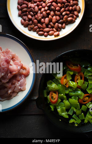 Pieces of chicken, beans. Pepper and chili in a frying pan closeup vertical Stock Photo
