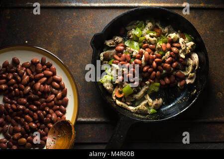 Beans are spread in a frying pan with pepper and chicken horizontal Stock Photo