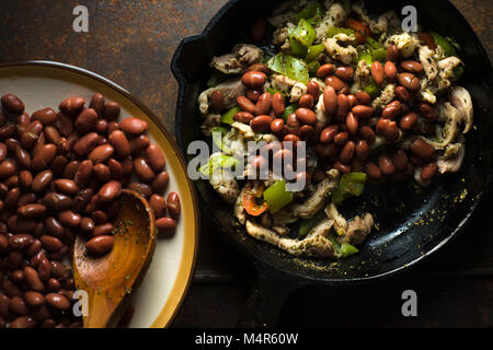Beans are spread in a frying pan with pepper and chicken closeup horizontal Stock Photo