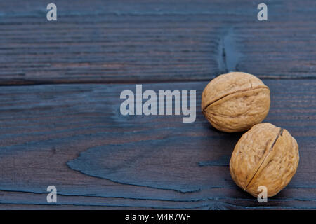 Two walnuts on a wooden table Stock Photo