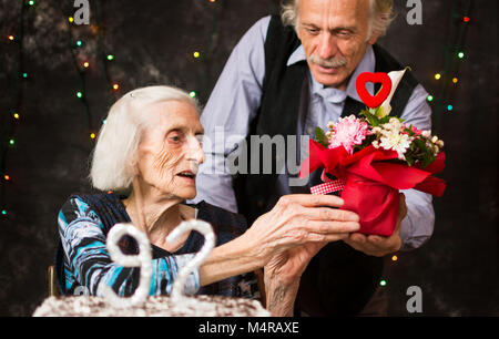 Senior woman receiving a  present on birthday celebration Stock Photo