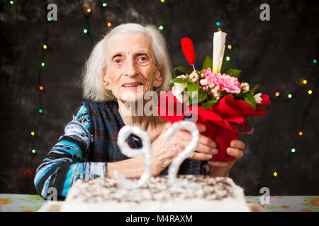 Senior woman holding a  present on birthday celebration Stock Photo