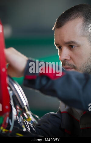 Electrician builder engineer screwing and testing equipment in fuse box Stock Photo