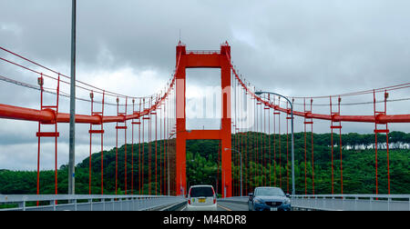 Hirado bridge which connects the islands of Hirado and Kyushu, Nagasaki Prefecture, Japan. Two cars on the bridge and trees in the background. Stock Photo