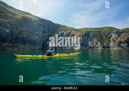 Sea kayaker beneath the cliffs of Howth Head, County Dublin, Ireland. Stock Photo