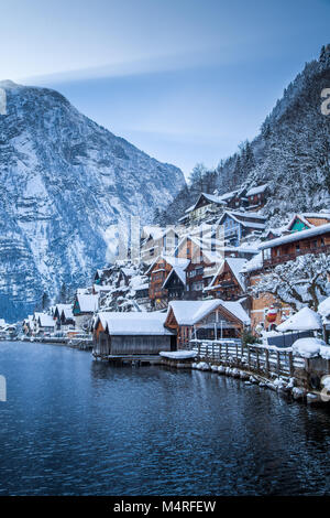 Classic postcard view of traditional wooden houses in famous Hallstatt lakeside town in the Alps in mystic twilight during blue hour at night, Austria Stock Photo