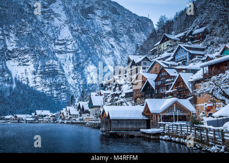 Classic postcard view of traditional wooden houses in famous Hallstatt lakeside town in the Alps in mystic twilight during blue hour at night, Austria Stock Photo