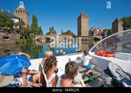 Tourist enjoys the view from excursion boat on Ponts couvert, medieval bridge at La Petite France, Strasbourg, Alsace, Bas-Rhin, France, Europe