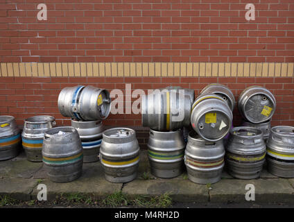 Stainless steel beer casks piled up on stone flag pavement in bury lancashire uk Stock Photo