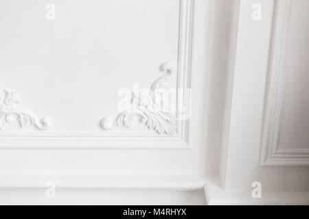 Expensive interior. Stucco elements on light luxury wall. White patterned. Mouldings element from gypsum. Roccoco style Stock Photo