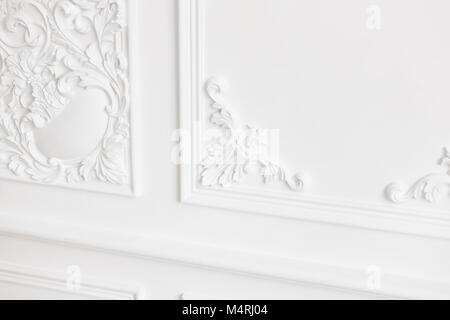 Expensive interior. Stucco elements on light luxury wall. White patterned. Mouldings element from gypsum. Roccoco style Stock Photo