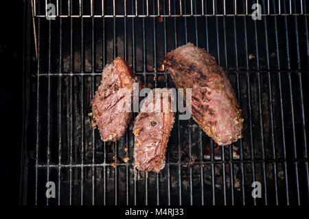 brazilian barbecue bbq on charcoal with three pieces of meat Stock Photo
