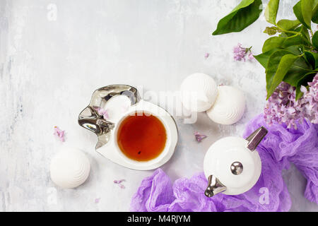 Relaxation time concept. Homemade zephyr with cup of tea on a cozy kitchen table. Copy space, top view flat lay background. Stock Photo