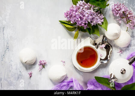 Relaxation time concept. Homemade zephyr with cup of tea on a cozy kitchen table. Copy space, top view flat lay background. Stock Photo