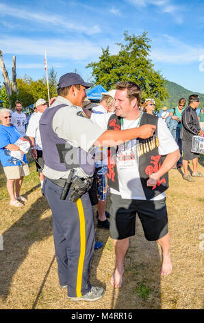 Chief Justin George of Tsleil-Waututh Nation greets First Nations RCMP officer at declaration to protect the Salish Sea. Many People, One Canoe. Salis Stock Photo