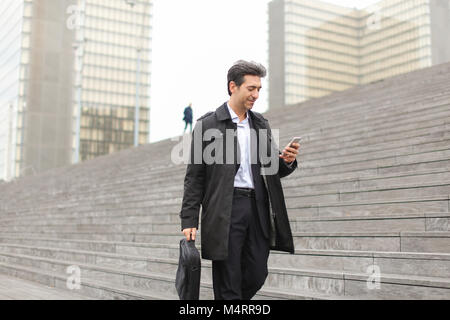 business man walking using smartphone to watch photos. Stock Photo