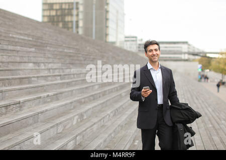business man walking using smartphone to watch photos. Stock Photo