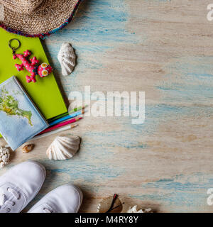 Travel concept background. Overhead view of traveler's accessories. Sneakers, passport, notebook, colored pencils, key ring, shells, hat, sunglasses. Stock Photo