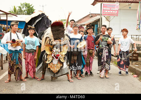 Local indonesian boys performing traditional lion dance with musical instruments on the street in Bali, Indonesia. Stock Photo