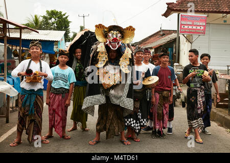 Local indonesian boys performing traditional lion dance with musical instruments on the street in Bali, Indonesia. Stock Photo