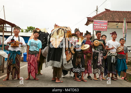 Local indonesian boys performing traditional lion dance with musical instruments on the street in Bali, Indonesia. Stock Photo