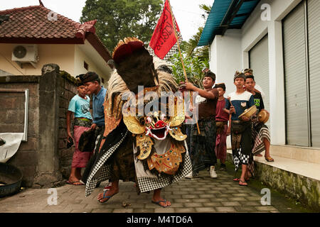 Local indonesian boys performing traditional lion dance with musical instruments on the street in Bali, Indonesia. Stock Photo