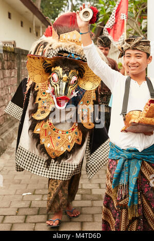 Local indonesian boys performing traditional lion dance with musical instruments on the street in Bali, Indonesia. Stock Photo