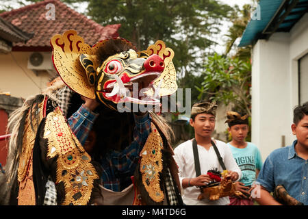 Local indonesian boys performing traditional lion dance with musical instruments on the street in Bali, Indonesia. Stock Photo