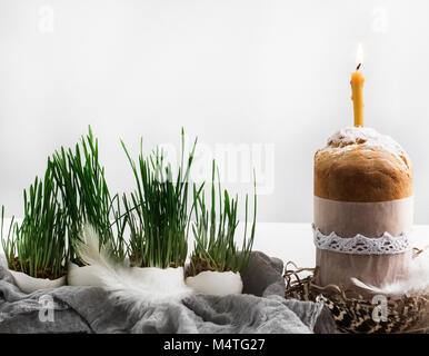 Fragrant cupcake on a background of fresh, green grass in pots. Preparing for Easter Stock Photo