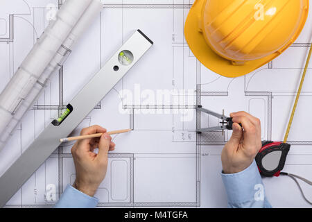 High Angle View Of Architect Hands Working On Blueprint Stock Photo