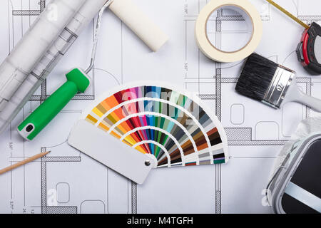 High Angle View Of Color Guide Swatch On Blueprints With Paint Roller And Paint Brush Stock Photo