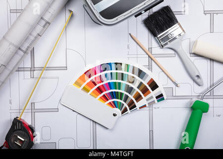 High Angle View Of Color Guide Swatch On Blueprints With Paint Roller And Paint Brush Stock Photo