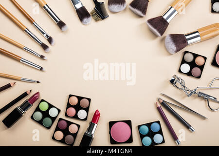 Makeup Brushes And Make-up Products Set Arranged In A Circle On Beige Background Stock Photo