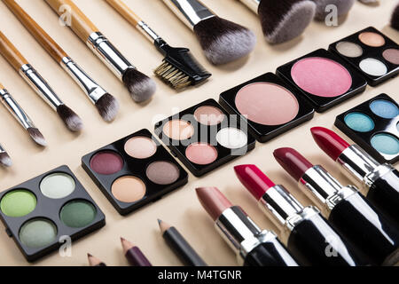 Various Type Of Makeup Brushes And Make-up Products Arranged In A Row On Beige Background Stock Photo