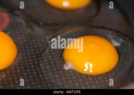 raw eggs lies in a black pan Stock Photo