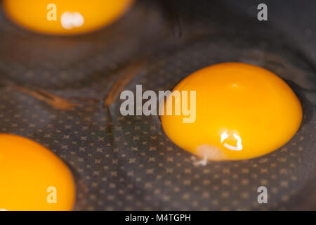 raw eggs lies in a black pan Stock Photo