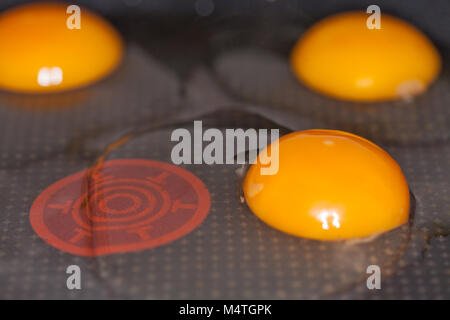 raw eggs lies in a black pan Stock Photo