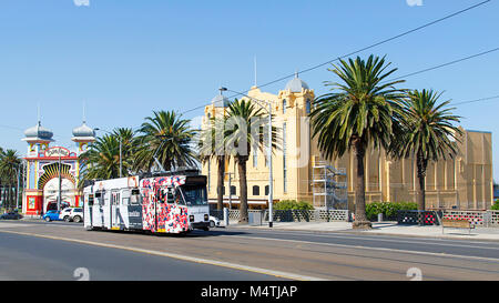 Melbourne, Australia: April 04, 2017: A tram leaves Acland Street and travels past Luna Park in St Kilda towards the city centre. Stock Photo