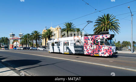 Melbourne, Australia: April 04, 2017: A tram leaves Acland Street and travels past Luna Park in St Kilda towards the city centre. Stock Photo