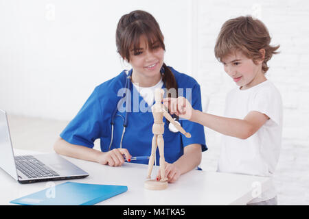 Doctor explain medicine to child using wooden doll Stock Photo