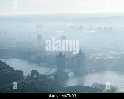 A cold and frosty dawn with air pollution over London's skyline with Tower Bridge and the Docklands Stock Photo