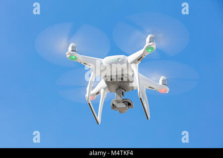 Low angle view of drone flying against clear blue sky Stock Photo