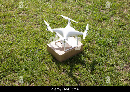 High angle view of drone successfully delivered parcel over grassy field Stock Photo