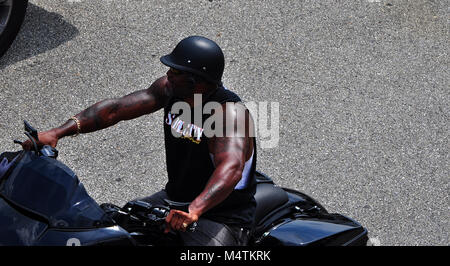 Man sitting stationary on his custom motorcycle with saddlebags Stock Photo